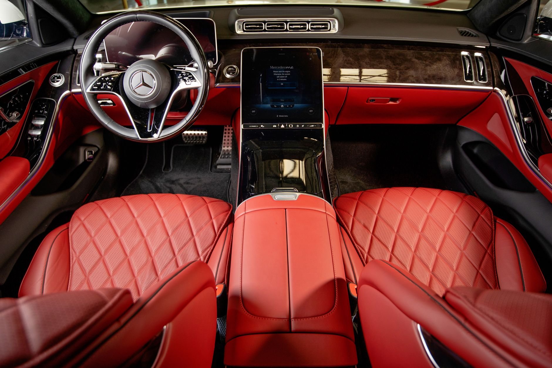 Elegant interior view of a luxury car with sleek red leather seats and high-tech dashboard.